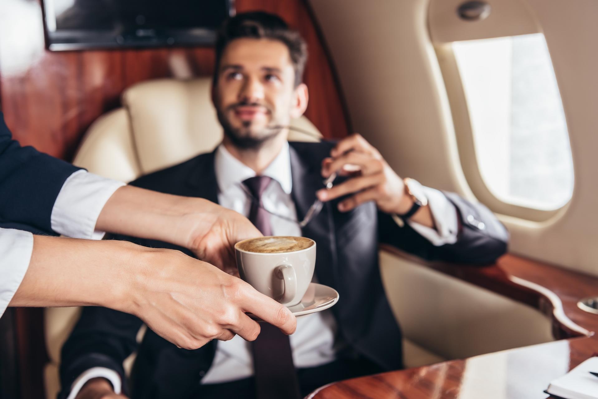handsome man ordering coffee in the plane